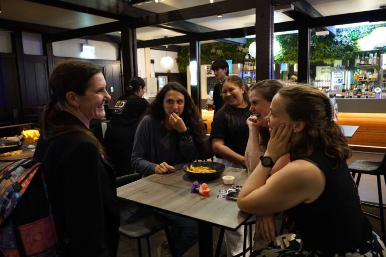 Dr Heather Bray and a group of students talking around a table in a tavern setting