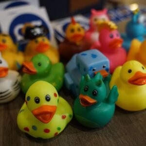 Rubber ducks of various types and designs, on a table next to some The SciComm Collective stickers