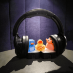 a set of headphones with three differently brightly coloured rubber ducks